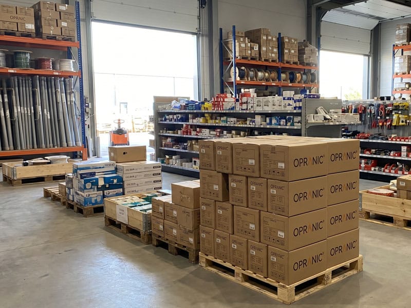 Professionelles Großhandelslager mit gemischten Produkten in Regalen und auf Paletten, das typische Handelsumfeld, in dem Opranic von Schwedens führenden Elektro und Sanitärgroßhändlern geführt wird
